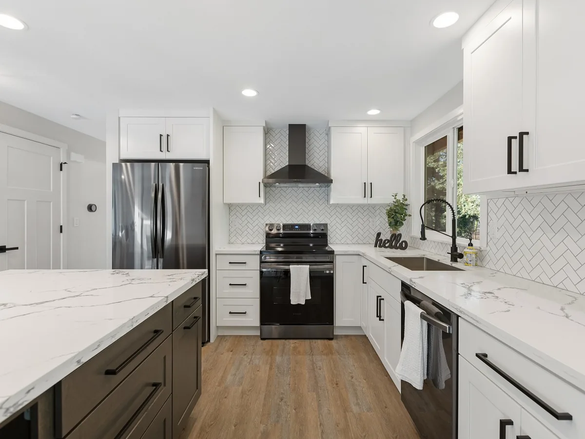After: modern white kitchen with quartz counters and herringbone tile backsplash